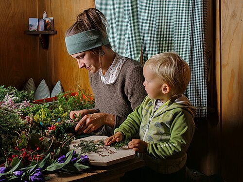 Anna, with Max supporting his mother, decorates a sign for the Almabtrieb